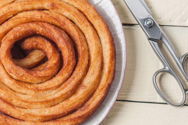 Tijeras junto a plato de churros