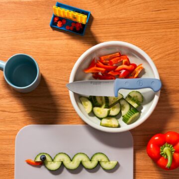 Ambiente con el cuchillo infantil Wüsthof Junior de color azul y verdura cortada – Cuchillalia.com