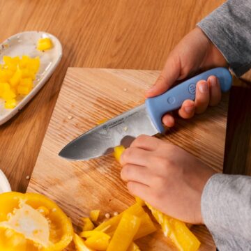 Ambiente con el cuchillo infantil Wüsthof Junior de color azul cortando – Cuchillalia.com